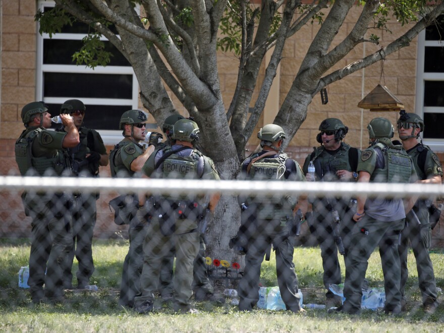 Law enforcement stands outside Robb Elementary School after a shooting Tuesday in Uvalde, Texas.